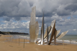 "Les Braves," a  nine-meter tall stainless steel sculpture by Anilore Ban rises from the sand at Omaha Beach near St. Laurent-sur-Mer, France. It honors all those men who landed here to liberate France. The sculpture has 3 elements: 1) Wings of Hope, 2) Rise, Freedom!, and 3) Wings of Fraternity. 